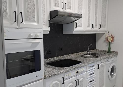 萨莫拉Peña de Francia的白色的厨房设有水槽和炉灶。