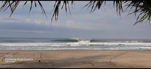 WainapalRumah Pantai Krui的海浪大浪的海滩