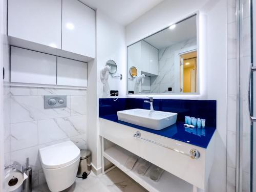 巴统ORBI CITY Beautiful Luxurios Panoramic View on batumi的一间带水槽、卫生间和镜子的浴室