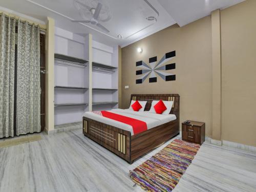 斋浦尔OYO Flagship Hotel Hastinapur Residency的一间卧室配有红色枕头的床