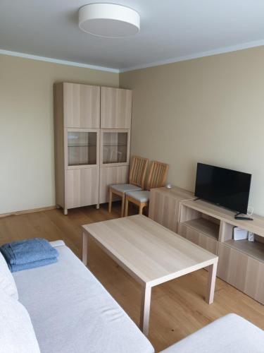 坎达瓦Ozolu apartement的带沙发、桌子和电视的客厅