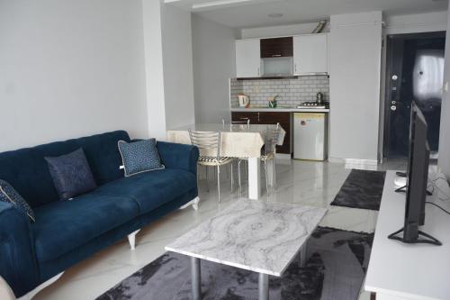 吉拉克Hera Rezidans的一间带蓝色沙发的客厅和一间厨房