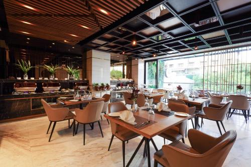 科伦坡Zest Metropole的一间带木桌椅的餐厅和一间酒吧
