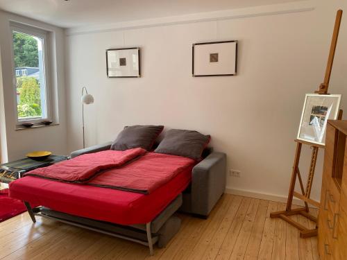 奥斯纳布吕克Ferienwohnung am Schölerberg的一间卧室配有一张带红色毯子的床