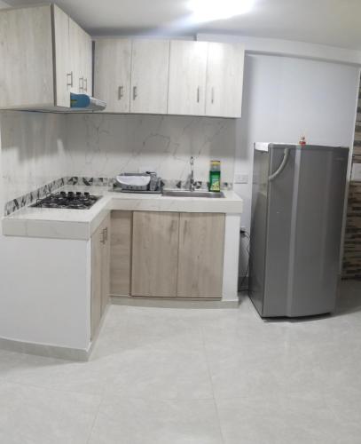 内瓦Apartamento Neiva的厨房配有白色橱柜和冰箱。