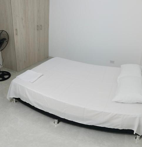 内瓦Apartamento Neiva的一张位于带白色床单的房间的床铺