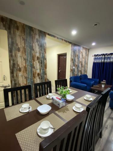 斯利那加The Khayabaan - Luxurious Home Stay Away From Home的一间带桌子和蓝色沙发的用餐室