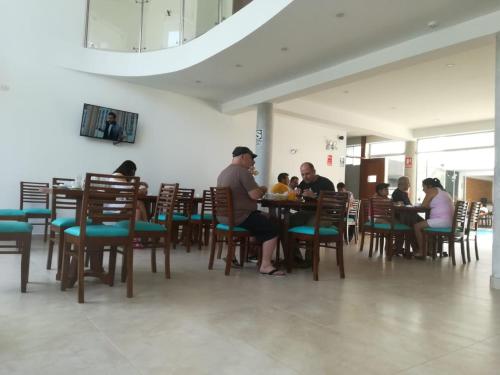 帕拉卡斯Hotel Golf Paracas的一群坐在餐厅桌子上的人