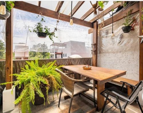 墨西哥城Suites Club de Golf的庭院设有木桌、椅子和植物