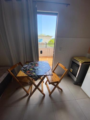 安格拉杜斯雷斯Residencial Aquidabã的一间带炉灶的客房内的一张桌子和两把椅子
