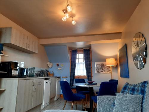 托伯莫里Strome Beag的厨房配有蓝色的椅子和桌子