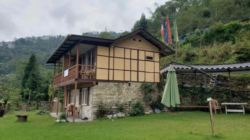 佩林Phamlhakhang Ecohomestay的前面有一把绿色雨伞的房子