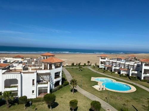 艾西拉Appartement de vacances BERALMAR CHEZ HOUDA的享有度假胜地的空中景致,设有游泳池和海滩