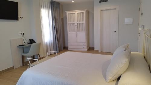 阿尔克萨尔Hotel Vinoteca Alquezar - Adults Only -的卧室配有一张白色大床和一张书桌