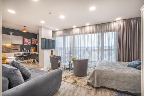 维尔纽斯Vilnius city best view apartments的一间卧室配有一张床,客厅配有厨房