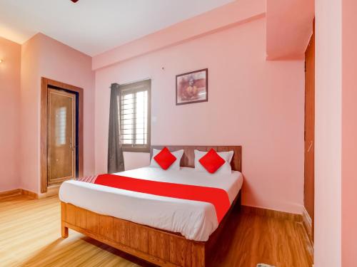 博帕尔Hotel Crown Square的一间卧室配有一张带红色枕头的大床