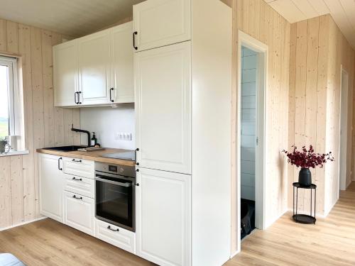 霍芬REY Stays - House的厨房配有白色橱柜和冰箱。
