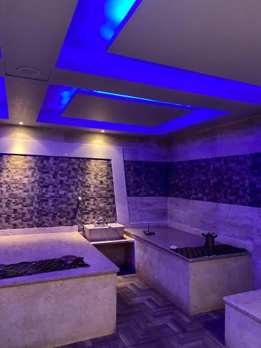 赫尔格达Apartment in el karma aqua beach resort hurghada near El gouna的浴室设有两个浴缸和蓝色灯光。