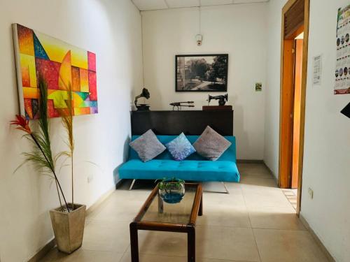 马尼萨莱斯Hostal Zaguán Caldense的客厅配有蓝色的沙发和桌子