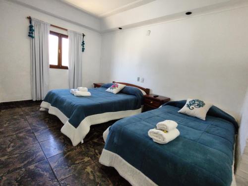 塔菲德尔瓦勒Hotel Los Cuartos的配有两张床铺的客房提供蓝色的床单和毛巾