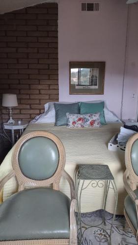 斯阔谷Rustic Rooms by Kings Canyon & Sequoia National Parks的一间卧室配有一张带两把椅子和一张桌子的床。