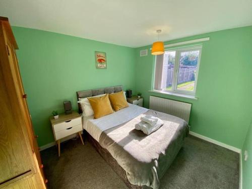 BentleyBakers House - Contractor Suitable的绿色卧室设有床和窗户