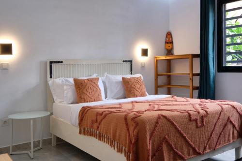 恩加帕鲁Villa Umy的一间卧室配有一张带橙色毯子的床