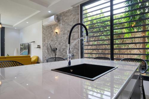 恩加帕鲁Villa Umy的厨房配有水槽和带椅子的柜台。