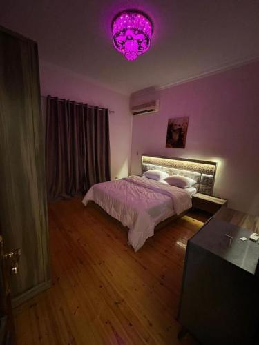 十月六日城Villa With A Private Garden In Beverly Hills的紫色卧室配有一张床和粉红色的灯光