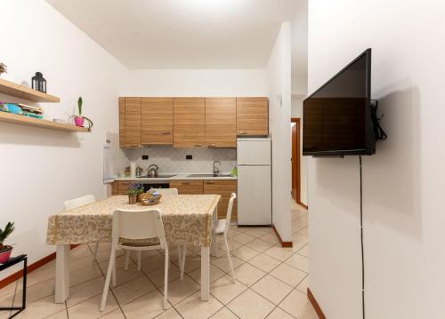 布雷西亚Holiday Apartment - Brescia centro - PARCHEGGIO PRIVATO的厨房以及带桌子和电视的用餐室。