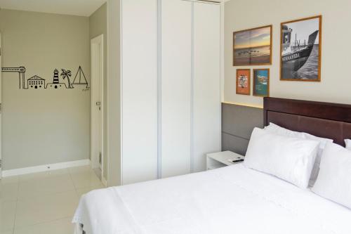 萨尔瓦多Apartamento Aconchegante Beira-Mar Ondina的卧室配有白色的床和木制床头板