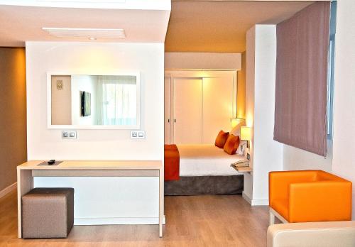 马略卡岛帕尔马BQ奥古斯塔酒店的客房设有一张床和一张带镜子的书桌