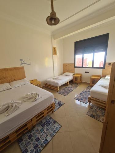 依索安LAFAMILIA SURF imsouane的客房设有两张床和大窗户。