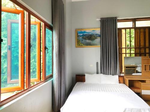 北市Nhà Nghỉ Sơn Lâm - Ba Bể lake Best view的一间设有床铺的卧室,位于带窗户的房间内