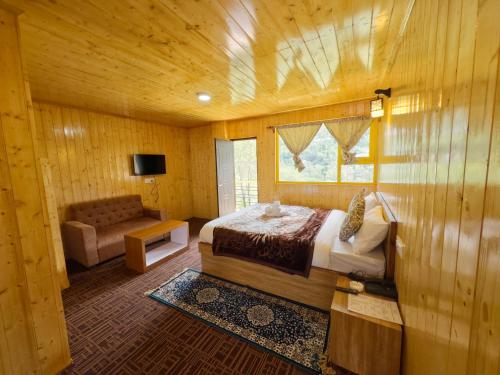 拉冲Apple Valley Cottages Lachung的卧室配有床、椅子和窗户。
