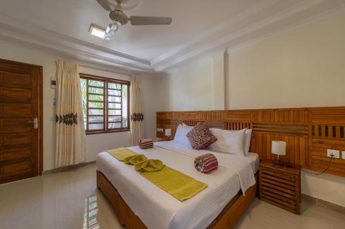 芭环礁Kamadhoo Inn的一间卧室设有一张大床和一个窗户。