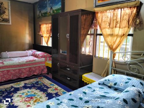 甲抛峇底Homestay Teratak Kayu kota Aur的一间设有两张床和一个梳妆台的房间以及一间卧室