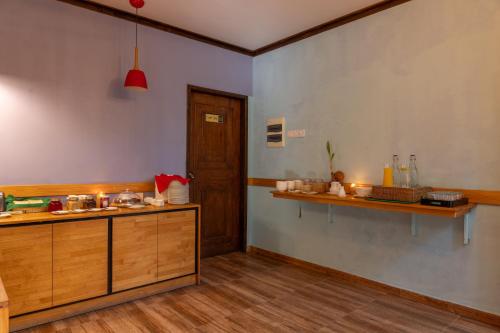 芭环礁Kamadhoo Inn的厨房配有木制橱柜和台面
