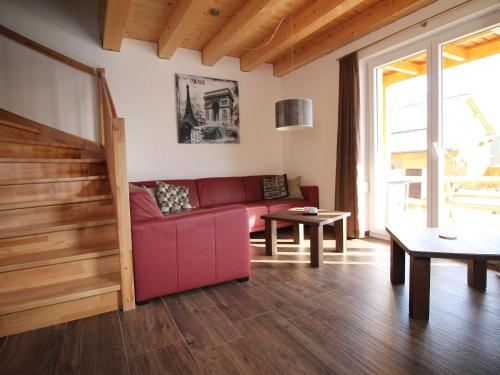 克查赫Chalet in ski area in Koetschach-Mauthen的客厅配有红色的沙发和桌子