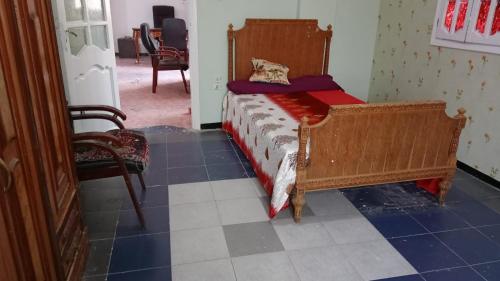 曼苏拉غرفه واحده فقط داخل شقه بها سرير ١٢٠ سم ومروحه ودولاب وكراسي的卧室配有一张床,铺有蓝色瓷砖地板。