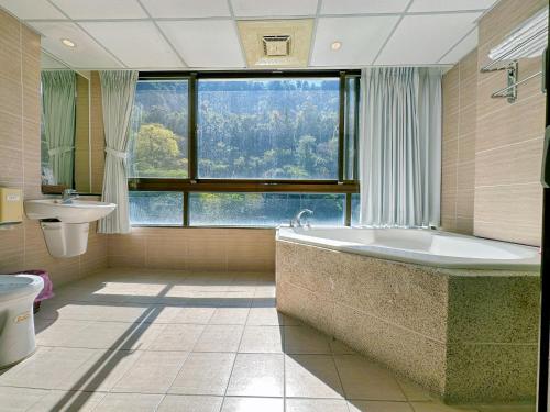 和平区Ming Zhi Hot Spring Hotel Building A的一间带大窗户和浴缸的浴室
