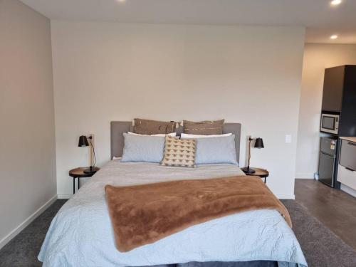 瓦纳卡Guest House on Sapphire的一间卧室配有一张带2个床头柜的大床