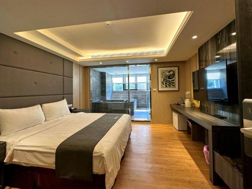和平区Ming Zhi Hot Spring Hotel Building A的一间卧室配有一张大床和电视
