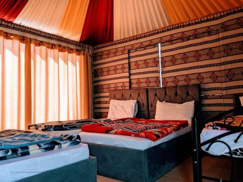 瓦迪拉姆Wadi Rum Camp & Jeep Tour的一间卧室设有两张床,墙上设有窗帘