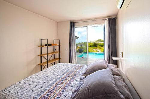 Cul de SacVilla Manowells的一间卧室配有一张床,享有游泳池的景色