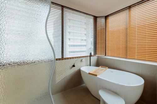 高雄Just Inn Kaohsiung 正旅馆-高雄馆的一间带白色浴缸和窗户的浴室