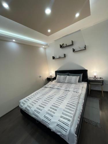BečejApartman Central A&D的卧室配有一张带两张桌子的大型白色床