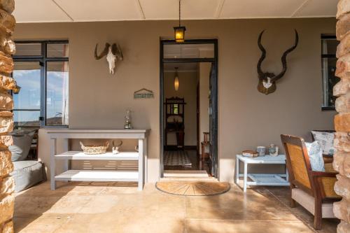阿马卡拉保护区Tygerfontein Safari Villa的客厅配有白色桌子和墙上的 ⁇ 角