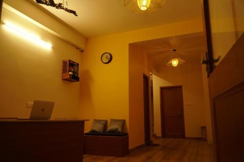 马拉里Firefly Hostel的一间设有黄色墙壁和墙上时钟的房间