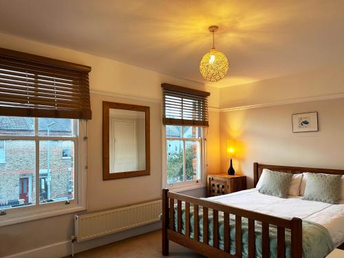 伦敦Daisy’s Place in London的一间卧室设有一张床和两个窗户。